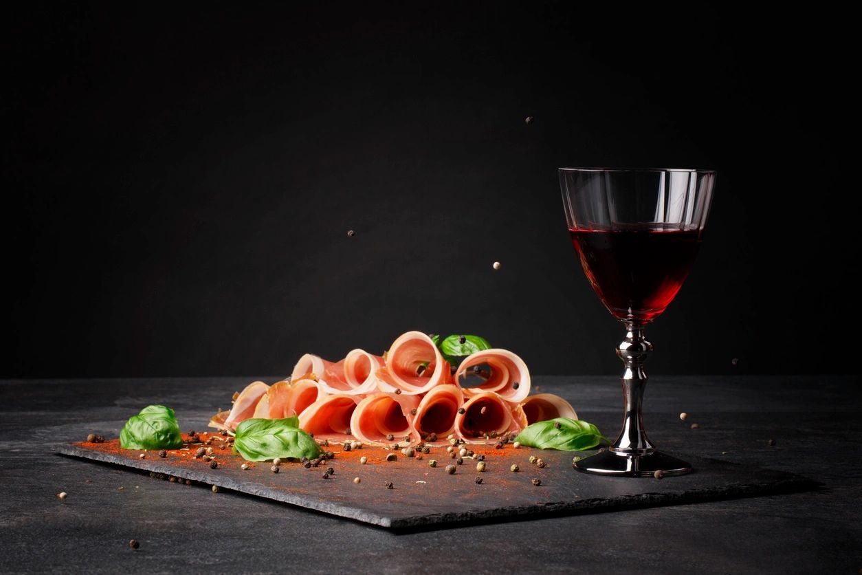 Copa de vino tinto con botana gourmet